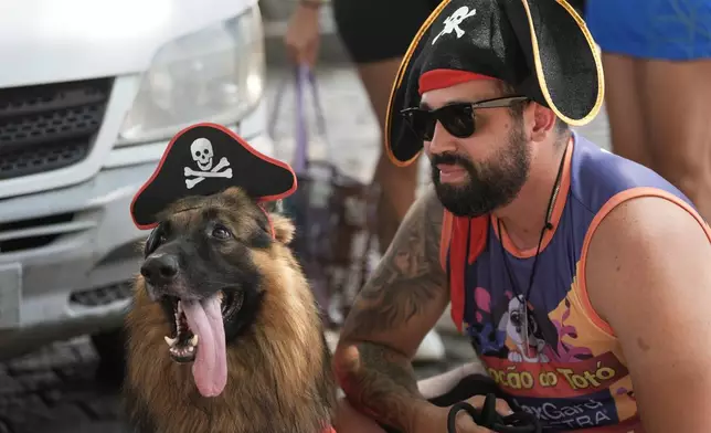 A dog and its owner wear pirate costume during the "Blocao" Carnival dog parade in Rio de Janeiro, Saturday, Feb. 14, 2026. (AP Photo/Silvia Izquierdo)