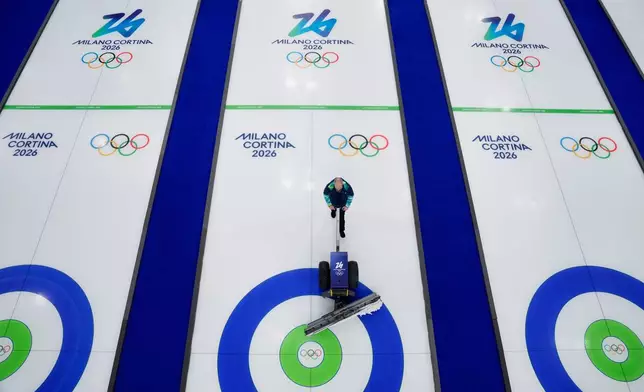 Curling ice sheets are prepared ahead of the first competition at the 2026 Winter Olympics in Cortina d'Ampezzo, Italy, Wednesday, Feb. 4, 2026. (AP Photo/David J. Phillip)