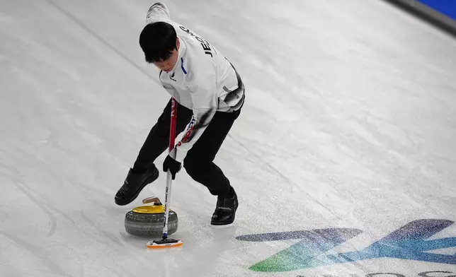 South Korea's Yeongseok Jeong sweeps a stone, during the mixed doubles round robin phase of the curling competition against Sweden, at the 2026 Winter Olympics, in Cortina d'Ampezzo, Italy, Wednesday, Feb. 4, 2026. (AP Photo/Fatima Shbair)