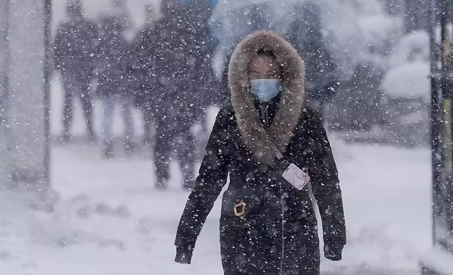 A pedestrian walks along 42nd Street near Bryant Park during a snow storm, Monday, Feb. 23, 2026, in New York. (AP Photo/Seth Wenig)