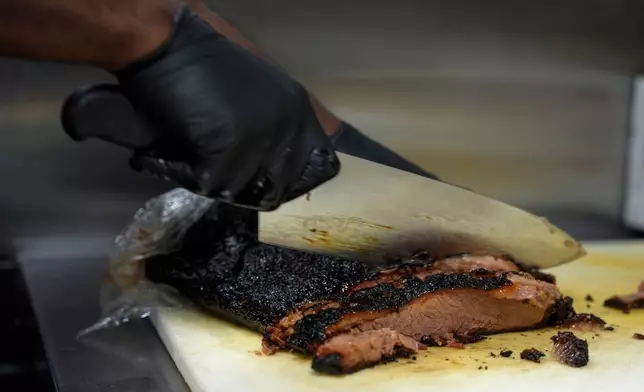 FILE - A line cook slices beef brisket June 12, 2024, at a barbecue restaurant in Cincinnati. (AP Photo/Joshua A. Bickel, File)