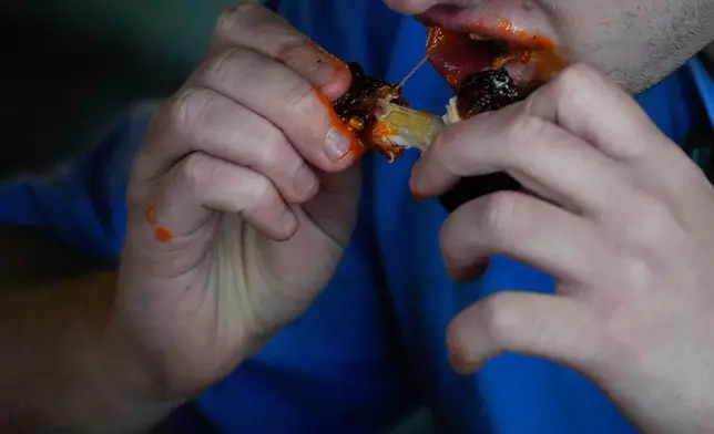 FILE - A man eats a chicken wing June 12, 2024, at a barbecue restaurant in Cincinnati. (AP Photo/Joshua A. Bickel, File)