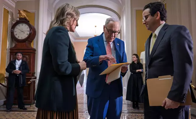 Senate Minority Leader Chuck Schumer, D-N.Y., center, confers with an aide, left, and Sen. Brian Schatz, D-Hawaii, following a Senate Democratic Caucus meeting, at the Capitol in Washington, Tuesday, Feb. 3, 2026. (AP Photo/J. Scott Applewhite)