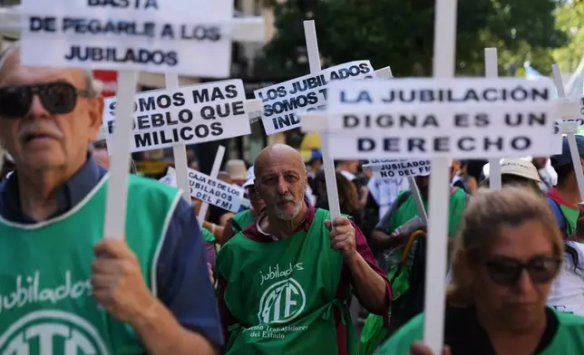 Demonstrators rally outside Congress with signs in defense of retired people during a protest against a labor reform bill proposed by President Javier Milei's government in Buenos Aires, Argentina, Friday, Feb. 27, 2026. (AP Photo/Rodrigo Abd)