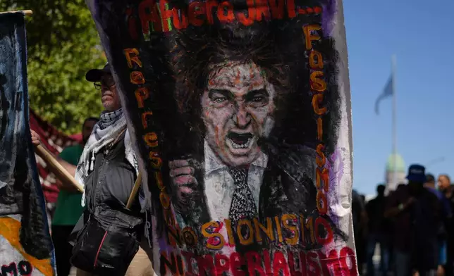 A protester holds a banner depicting Argentine President Javier Milei during a protest against a labor reform bill proposed by Milei's government in Buenos Aires, Argentina, Friday, Feb. 27, 2026. (AP Photo/Natacha Pisarenko)