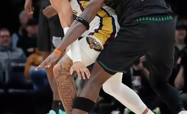 Minnesota Timberwolves guard Anthony Edwards (5) tries to strip the ball from New Orleans Pelicans guard Jeremiah Fears, left, in the first quarter of an NBA basketball game Friday, Feb. 6, 2026, in Minneapolis. (AP Photo/Bruce Kluckhohn)