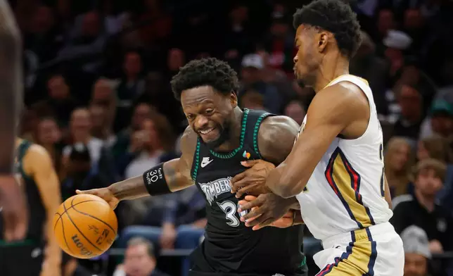 Minnesota Timberwolves forward Julius Randle, left, works against New Orleans Pelicans center Yves Missi in the first quarter of an NBA basketball game Friday, Feb. 6, 2026, in Minneapolis. (AP Photo/Bruce Kluckhohn)