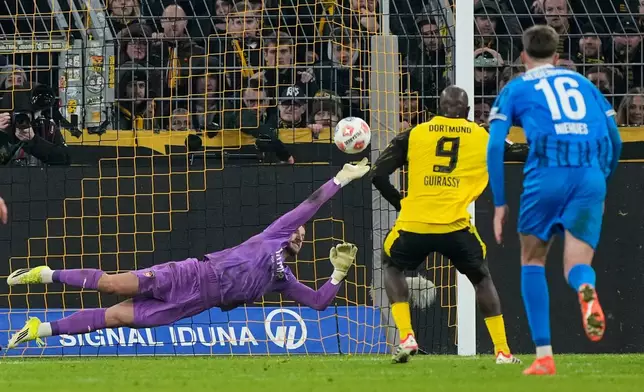 Dortmund's Serhou Guirassy scores his side's second goal from the penalty spot against Heidenheim's goalkeeper Diant Ramaj during the German Bundesliga soccer match between Borussia Dortmund and FC Heidenheim in Dortmund, Germany, Sunday, Feb. 1, 2026. (AP Photo/Martin Meissner)