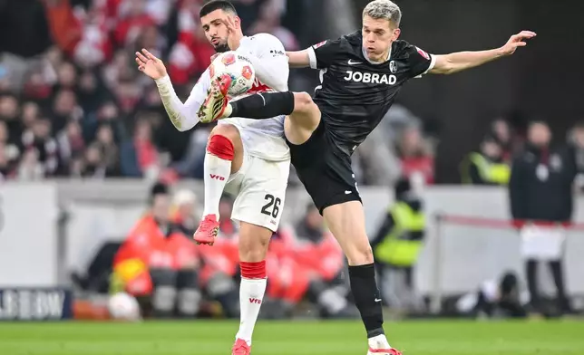 Freiburg's Matthias Ginter, right, and Stuttgart's Deniz Undav, left, challenge for the ball during the German Bundesliga soccer match between VfB Stuttgart and SC Freiburg in Stuttgart, Germany, Sunday, Feb. 1, 2026. (Harry Langer/dpa via AP)