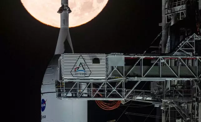 A full moon is seen shining over NASA’s SLS (Space Launch System) and Orion spacecraft, atop the mobile launcher in the early hours of Sunday, Feb. 1, 2026, at NASA’s Kennedy Space Center in Florida. (Sam Lott/NASA via AP)