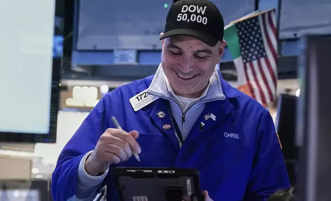 Trader Chris Lagana works on the floor of the New York Stock Exchange, Friday, Feb. 6, 2026, as the Dow Jones industrial average closed above the 50,000 level for the first time. (AP Photo/Richard Drew)