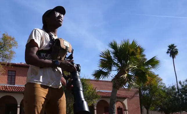 Robert Carter, of the Maricopa Bird Alliance, looks for lovebirds to photograph in Encanto Park, Jan. 18, 2026, in Phoenix. (AP Photo/Ross D. Franklin)