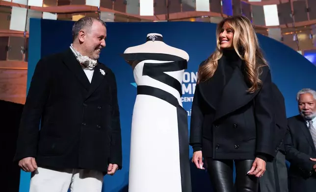 First lady Melania Trump and designer Hervé Pierre pose for a picture with her 2025 inaugural ball gown at the Smithsonian National Museum of American History, Friday, Feb. 20, 2026, in Washington. (AP Photo/Allison Robbert)