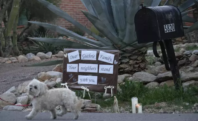 Lit candles next to a sign from neighbors supporting the Guthrie family outside of Nancy Guthrie’s house in the early morning hours of Sunday, Feb. 8, 2026 in Tucson, Ariz. (AP Photo/Ty ONeil)
