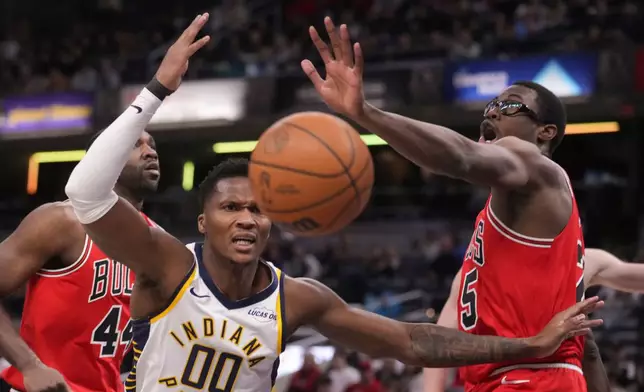 Indiana Pacers guard Bennedict Mathurin (00) and Chicago Bulls forward Jalen Smith (25) reach for a loose ball during the first half of an NBA basketball game in Indianapolis, Wednesday, Jan. 28, 2026. (AP Photo/Michael Conroy)