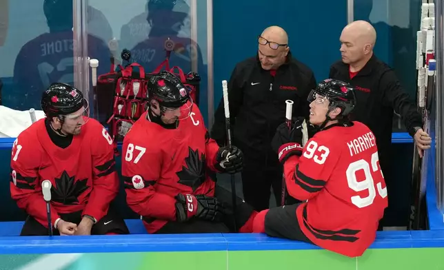 Canada's Sidney Crosby (87) is attended to after being injured during the second period of a men's ice hockey quarterfinal game between Canada and Czechia at the 2026 Winter Olympics, in Milan, Italy, Wednesday, Feb. 18, 2026. (AP Photo/Hassan Ammar)