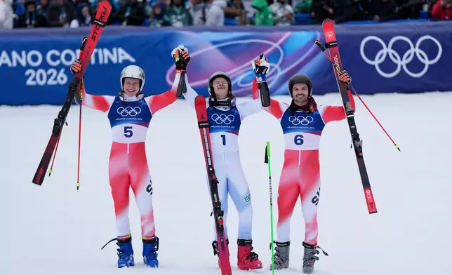 Brazil's Lucas Pinheiro Braathen, center, winner of a gold medal in an alpine ski, men's giant slalom race, celebrates with silver medalist Switzerland's Marco Odermatt, left, and bronze medalist Switzerland's Loic Meillard, at the 2026 Winter Olympics, in Bormio, Italy, Saturday, Feb. 14, 2026. (AP Photo/Julia Demaree Nikhinson)