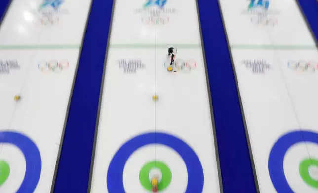 South Korea's Kim Seon-yeong sweeps in front of a stone while competing during a curling mixed doubles round robin session against Estonia at the 2026 Winter Olympics, in Cortina d'Ampezzo, Italy, Sunday, Feb. 8, 2026. (AP Photo/David J. Phillip)