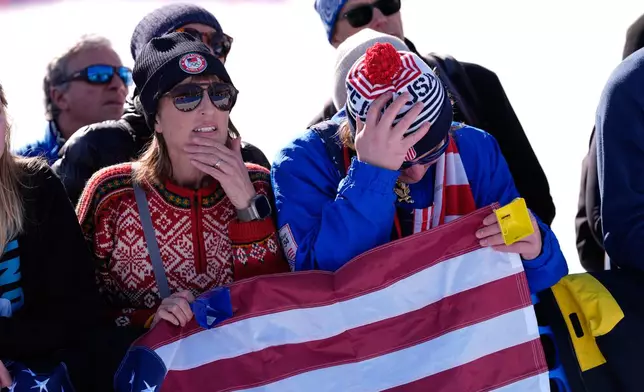 Spectators react after United States' Lindsey Vonn crashed during an alpine ski women's downhill race, at the 2026 Winter Olympics, in Cortina d'Ampezzo, Italy, Sunday, Feb. 8, 2026. (AP Photo/Robert F. Bukaty)