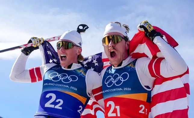 Ben Ogden, right, and Gus Schumacher, of the United States, celebrate after winning the silver medal in the cross-country skiing men's team sprint free at the 2026 Winter Olympics, in Tesero, Italy, Wednesday, Feb. 18, 2026. (AP Photo/Kirsty Wigglesworth)