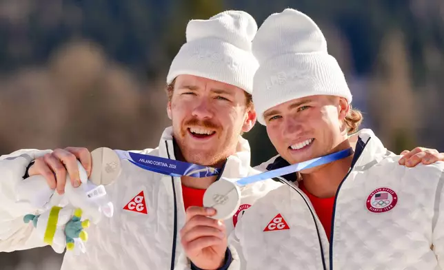 Ben Ogden and Gus Schumacher, of the United States, pose after winning the silver medal in the cross-country skiing men's team sprint free at the 2026 Winter Olympics, in Tesero, Italy, Wednesday, Feb. 18, 2026. (AP Photo/Kirsty Wigglesworth)