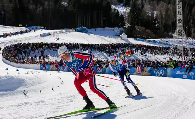 Johannes Hoesflot Klaebo, of Norway, and Gus Schumacher, of the United States, right, compete in the cross-country skiing men's team sprint free at the 2026 Winter Olympics, in Tesero, Italy, Wednesday, Feb. 18, 2026. (AP Photo/Evgeniy Maloletka)