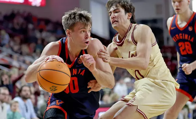 Virginia guard Dallin Hall, left, dribbles around Boston College guard Luka Toews, right, during the first half of an NCAA college basketball game Saturday, Jan. 31, 2026, in Boston. (AP Photo/Mark Stockwell)