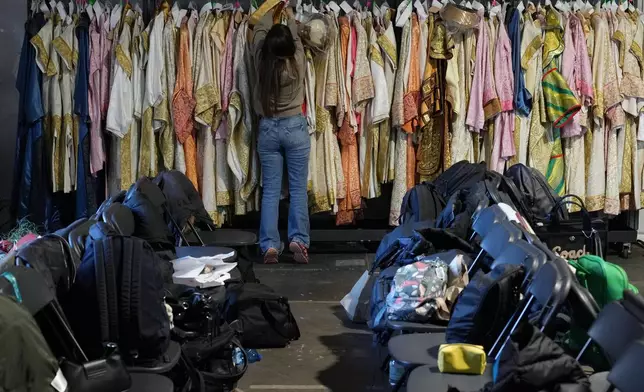 Dressmaker Luciana Donadio works in a dressing room outside the Arena ahead of the closing ceremony at the 2026 Winter Olympics, in Verona, Italy, Tuesday, Feb. 17, 2026. (AP Photo/Antonio Calanni)