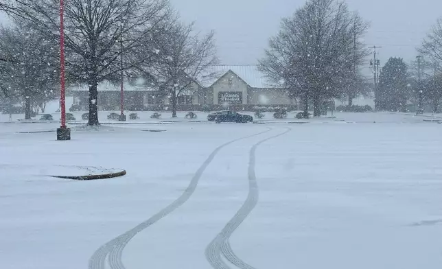 Snow falls outside a shopping center in Columbia, S.C., on Saturday, Jan. 31, 2026. (AP Photo/Jeffrey Collins)