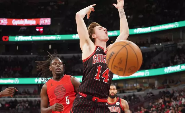 Chicago Bulls forward Matas Buzelis (14) is fouled by Portland Trail Blazers guard Jrue Holiday (5) during the second half in an NBA basketball game Thursday, Feb. 26, 2026, in Chicago. (AP Photo/David Banks)