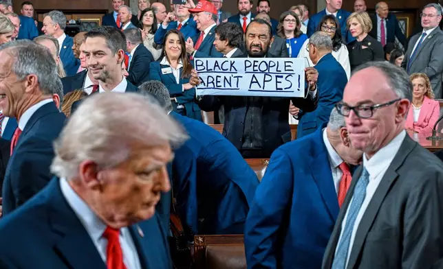 Rep. Al Green, D-Texas, holds up a sign as President Donald J. Trump walks by on his way to deliver the State of the Union address to a joint session of Congress in the House chamber at the U.S. Capitol in Washington, Tuesday, Feb. 24, 2026. (Kenny Holston/The New York Times via AP, Pool)