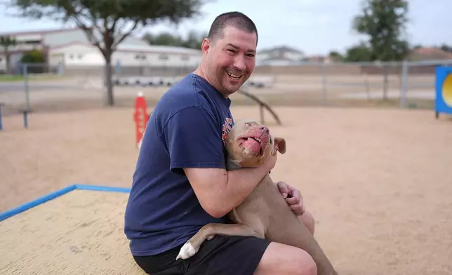 Ryan Vannest, 53, a retired high school teacher, spends time with his dog Ella at a dog park in Mission, Texas, Tuesday, Feb. 10, 2026. (AP Photo/Eric Gay)
