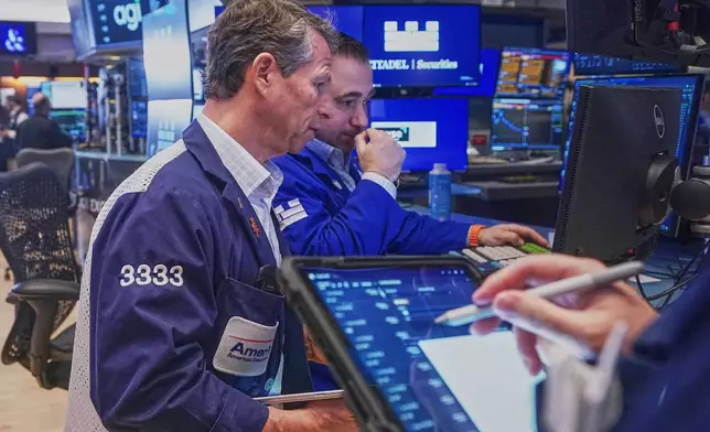 Trader Robert Charmak, left, and Specialist Genarro Saporito work on the floor of the New York Stock Exchange, Wednesday, Feb. 11, 2026. (AP Photo/Richard Drew)