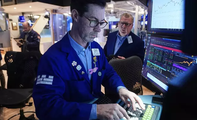 Specialist John McNierney, center, and trader Mathias Roberts, right, work on the floor of the New York Stock Exchange, Tuesday, Feb. 10, 2026. (AP Photo/Richard Drew)