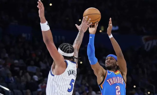 Oklahoma City Thunder guard Shai Gilgeous-Alexander (2) looks to shoot over Orlando Magic forward Paolo Banchero (5) during the second half of an NBA basketball game Tuesday, Feb. 3, 2026, in Oklahoma City. (AP Photo/Nate Billings)