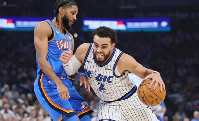 Orlando Magic guard Tyus Jones (2) drives against Oklahoma City Thunder guard Isaiah Joe, left, during the first half of an NBA basketball game, Tuesday, Feb. 3, 2026, in Oklahoma City. (AP Photo/Nate Billings)