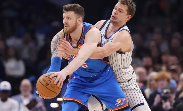 Oklahoma City Thunder center Isaiah Hartenstein, front, keeps the ball away from Orlando Magic forward Moritz Wagner, back, during the first half of an NBA basketball game, Tuesday, Feb. 3, 2026, in Oklahoma City. (AP Photo/Nate Billings)