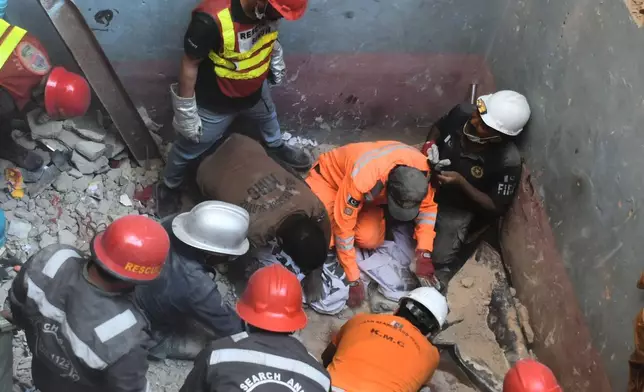Rescue workers recover a body from the rubble following a gas explosion in an apartment building in Karachi, Pakistan, Thursday, Feb. 19, 2026. (AP Photo/Ali Raza)