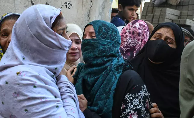 Women mourn over the death of their relatives near the site of a gas explosion in an apartment building, in Karachi, Pakistan, Thursday, Feb. 19, 2026. (AP Photo/Ali Raza)