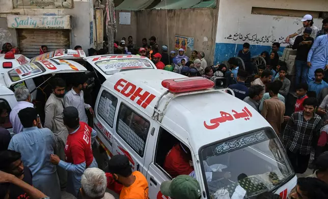 Rescue workers load a body into an ambulance after recovering it from the rubble following a gas explosion at an apartment building, in Karachi, Pakistan, Thursday, Feb. 19, 2026. (AP Photo/Ali Raza)