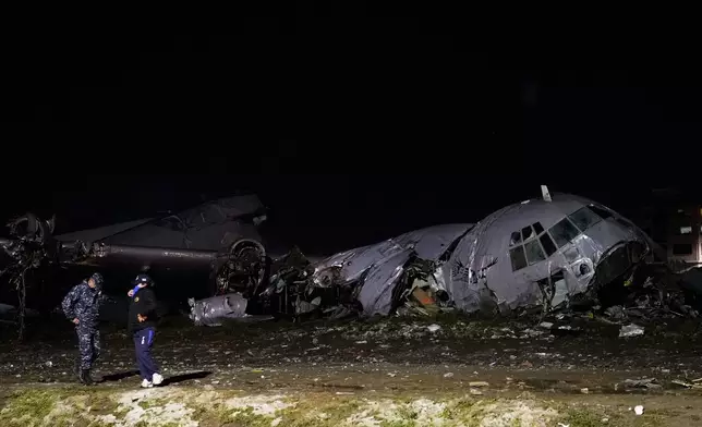 Police stands next to a plane that crashed in El Alto, Bolivia, Friday, Feb. 27, 2026. (AP Photo/Juan Karita)