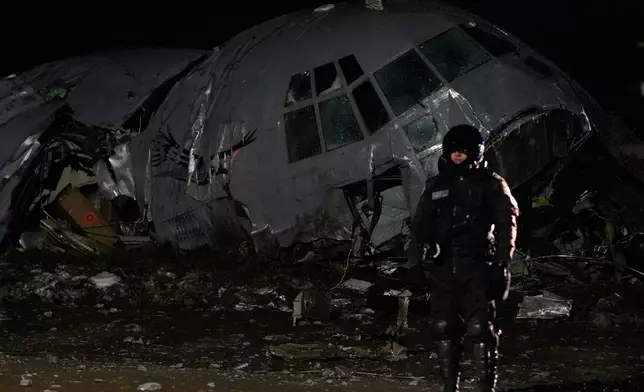 A military police stands next to a plane that crashed in El Alto, Bolivia, Friday, Feb. 27, 2026. (AP Photo/Juan Karita)