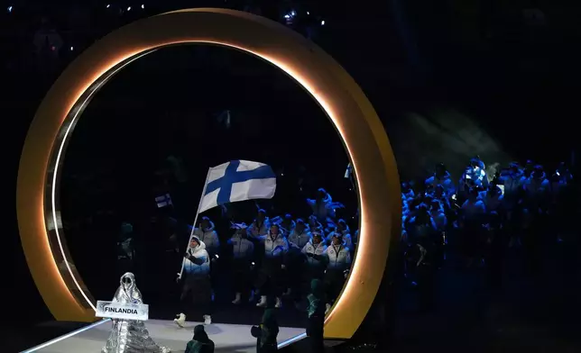 Finland's Mikko Lehtonen carries his country's flag during the Olympic opening ceremony at the 2026 Winter Olympics, in Milan, Italy, Friday, Feb. 6, 2026. (AP Photo/Carolyn Kaster)