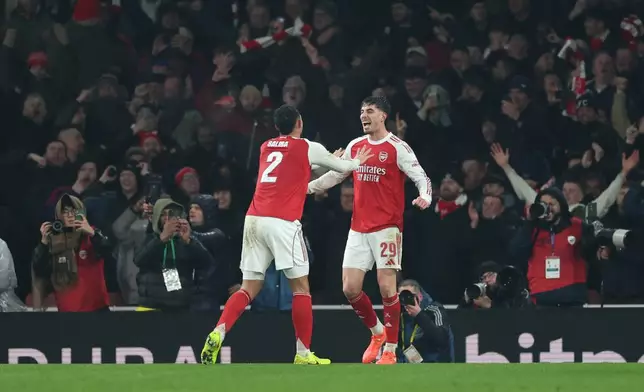 Arsenal's Kai Havertz, right, celebrates with Arsenal's William Saliba after scoring the opening goal during the English League Cup semifinal second leg soccer match between Arsenal and Chelsea in London, Tuesday, Feb. 3, 2026. (AP Photo/Ian Walton)