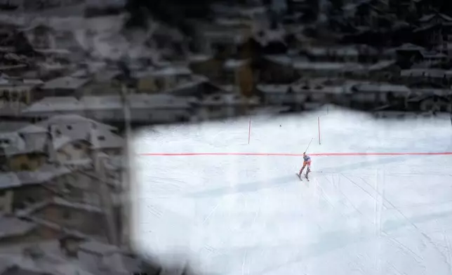 Spain's Joachim Salarich is photographed through a window as he arrives at the finish area during an alpine ski men's slalom race at the 2026 Winter Olympics in Bormio, Italy, Monday, Feb. 16, 2026. (AP Photo/John Locher)