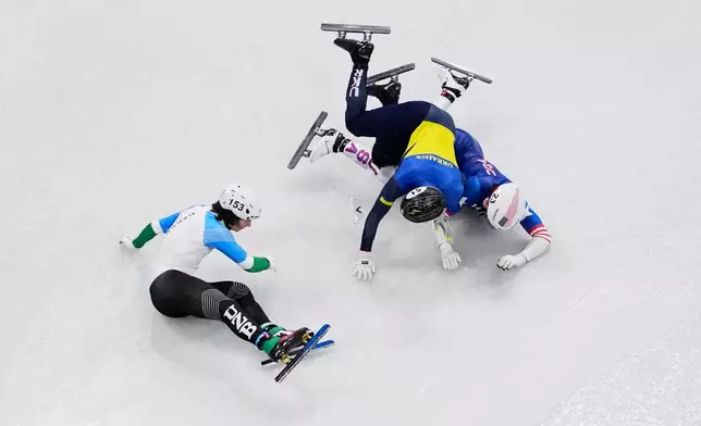 Brandon Kim of the United States, Oleh Handei of Ukraine and Daniil Eybog of Uzbekistan crash in the heats during the men's 500 meter short track speed skating at the 2026 Winter Olympics, in Milan, Italy, Monday, Feb. 16, 2026. (AP Photo/Bernat Armangue)