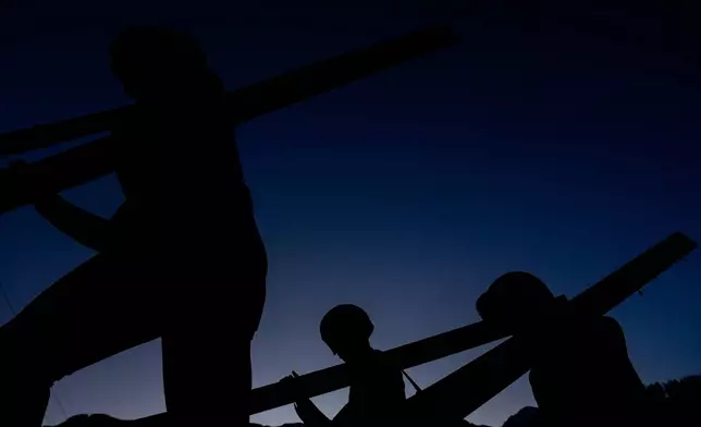 Athletes make their way to the ramp for their trial jump of the ski jumping men's super team competition at the 2026 Winter Olympics, in Predazzo, Italy, Monday, Feb. 16, 2026. (AP Photo/Matthias Schrader)