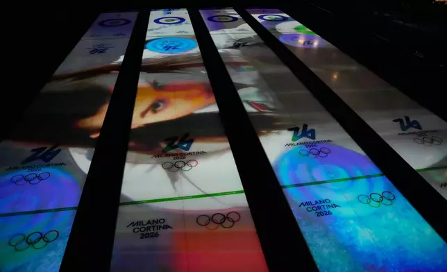 Images are projected on the sheets of ice before a men's curling round robin session at the 2026 Winter Olympics, in Cortina d'Ampezzo, Italy, Monday, Feb. 16, 2026. (AP Photo/David J. Phillip)