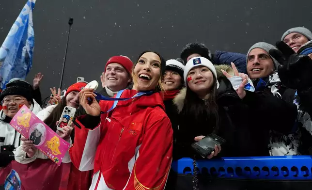 Silver medalist China's Eileen Gu celebrates with fans after the women's freestyle skiing big air finals at the 2026 Winter Olympics, in Livigno, Italy, Monday, Feb. 16, 2026. (AP Photo/Gregory Bull)