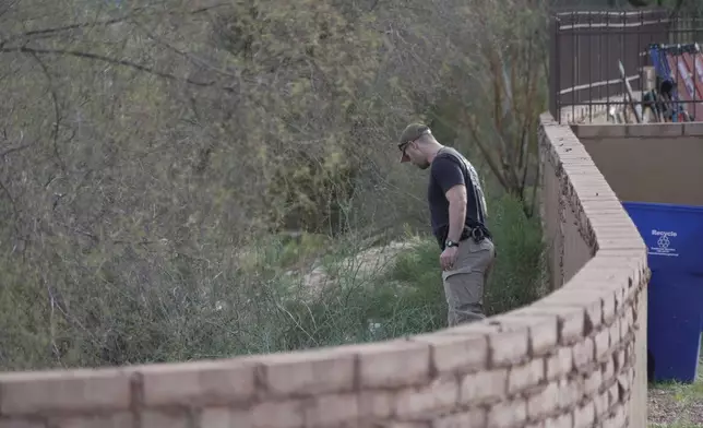An investigator walks around homes in the neighborhood where Annie Guthrie, whose mother Nancy Guthrie has been missing for more than a week, lives just outside Tucson, Ariz., on Tuesday, Feb. 10, 2026. (AP Photo/Ty ONeil)